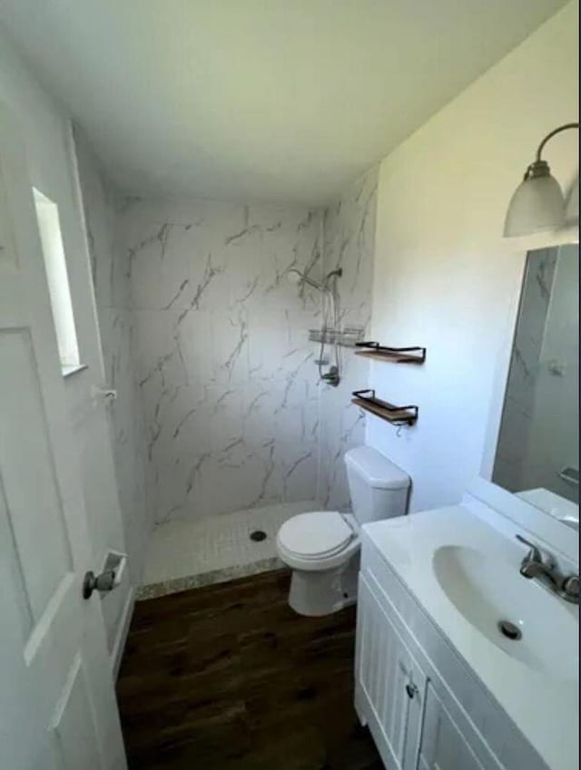 343 SE Husted Ter, Port Saint Lucie, FL 34983 - bathroom featuring vanity, a marble finish shower, wood finished floors, and toilet