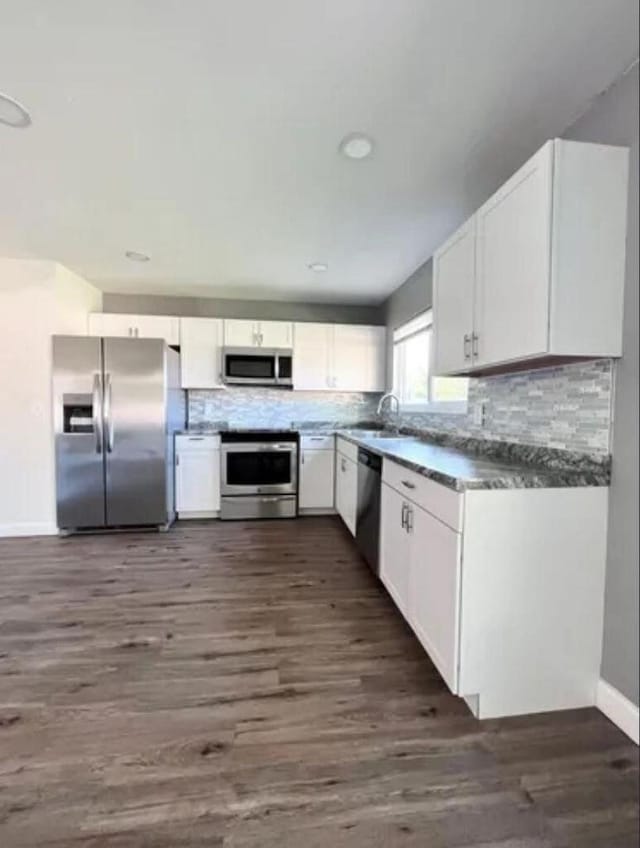 343 SE Husted Ter, Port Saint Lucie, FL 34983 - kitchen with appliances with stainless steel finishes, a sink, white cabinets, and backsplash
