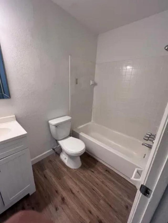 343 SE Husted Ter, Port Saint Lucie, FL 34983 - full bathroom featuring toilet, vanity, wood finished floors, and bathing tub / shower combination