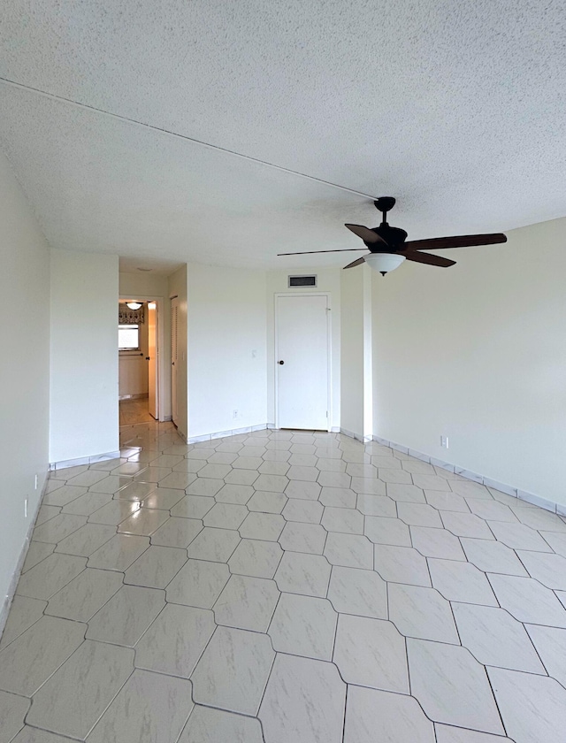 3524 Via Poinciana Unit 604, Greenacres, FL 33467 - spare room with a ceiling fan, a textured ceiling, and baseboards