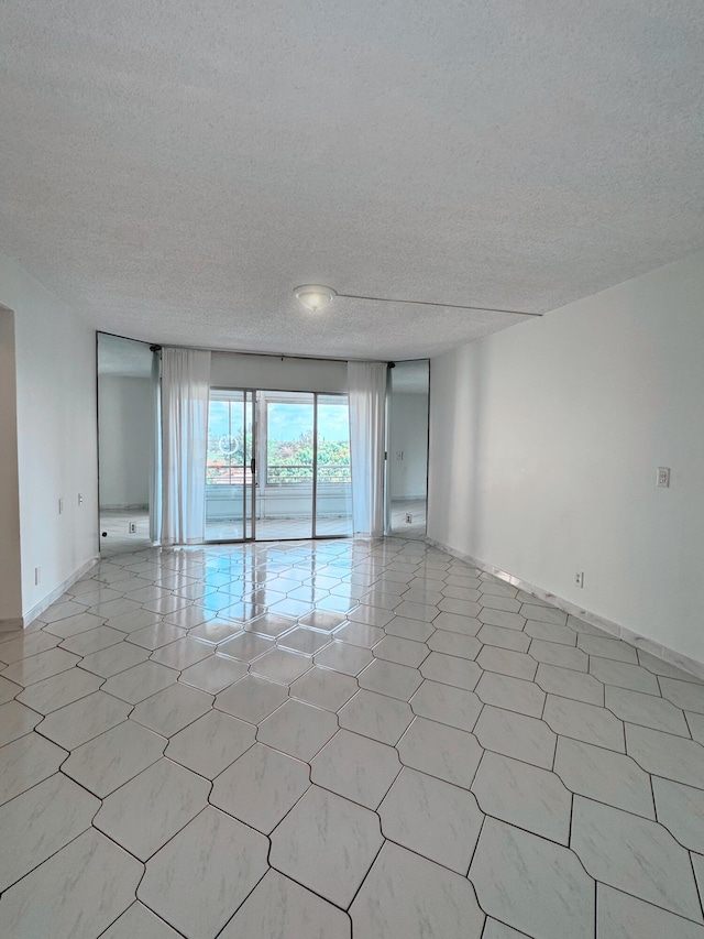 3524 Via Poinciana Unit 604, Greenacres, FL 33467 - empty room with a textured ceiling, baseboards, and light floors