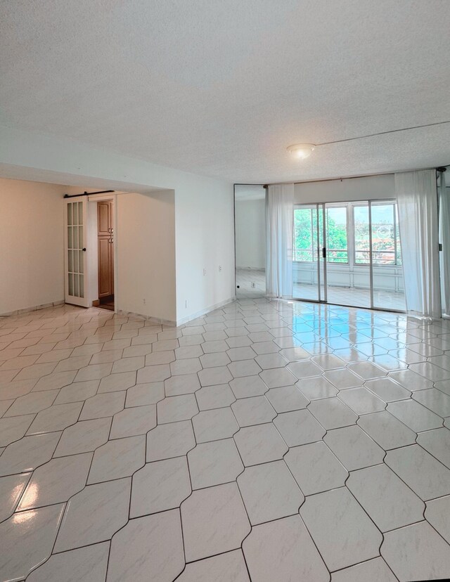 3524 Via Poinciana Unit 604, Greenacres, FL 33467 - empty room with a textured ceiling, baseboards, and light floors