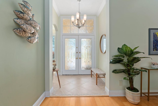 2683 SW Greenwich Way, Palm City, FL 34990 - foyer featuring crown molding, a chandelier, arched walkways, wood finished floors, and baseboards