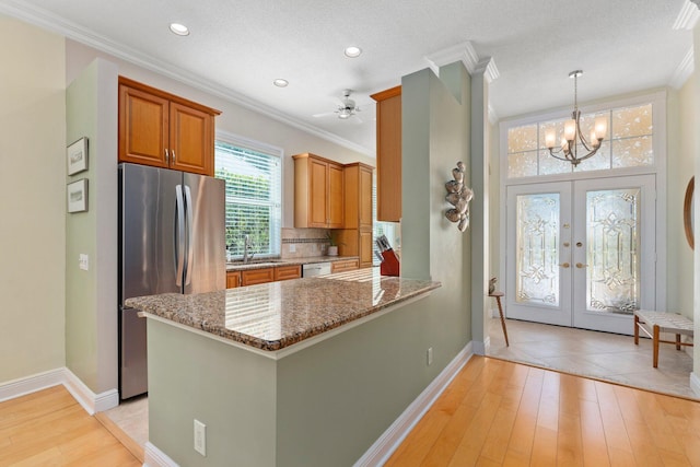 2683 SW Greenwich Way, Palm City, FL 34990 - kitchen with appliances with stainless steel finishes, ornamental molding, light stone countertops, baseboards, and light wood-style flooring