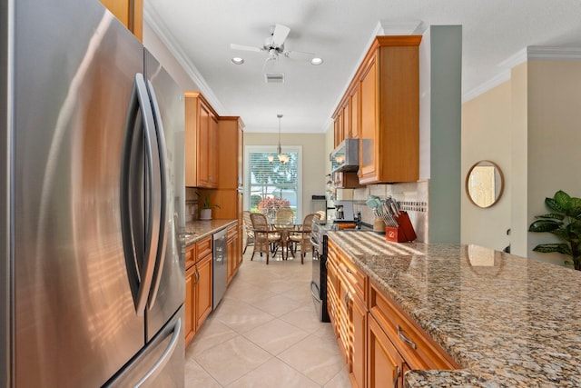 2683 SW Greenwich Way, Palm City, FL 34990 - kitchen with stainless steel appliances, tasteful backsplash, brown cabinets, dark stone counters, and ornamental molding