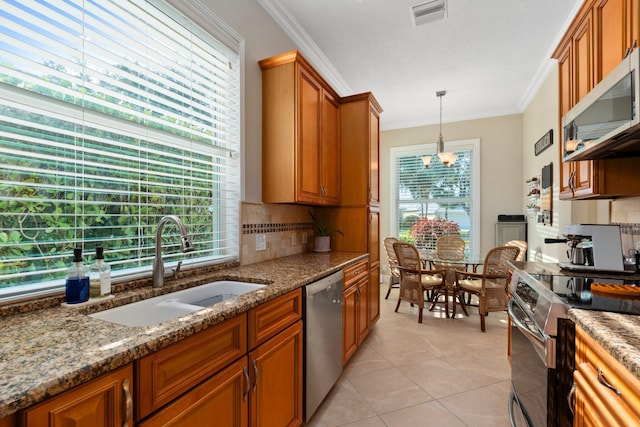 2683 SW Greenwich Way, Palm City, FL 34990 - kitchen featuring appliances with stainless steel finishes, a sink, brown cabinetry, tasteful backsplash, and ornamental molding