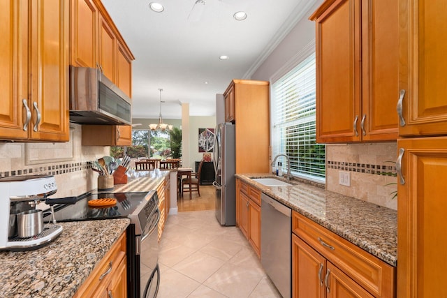 2683 SW Greenwich Way, Palm City, FL 34990 - kitchen featuring stainless steel appliances, a sink, light stone counters, brown cabinetry, and recessed lighting