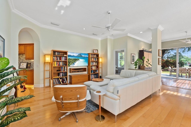 2683 SW Greenwich Way, Palm City, FL 34990 - living room featuring a ceiling fan, plenty of natural light, light wood-style floors, crown molding, and arched walkways