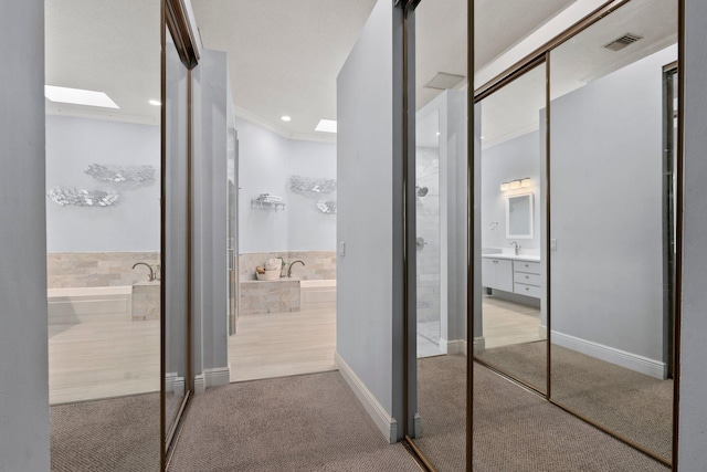 2683 SW Greenwich Way, Palm City, FL 34990 - hallway with a skylight, carpet floors, recessed lighting, and baseboards