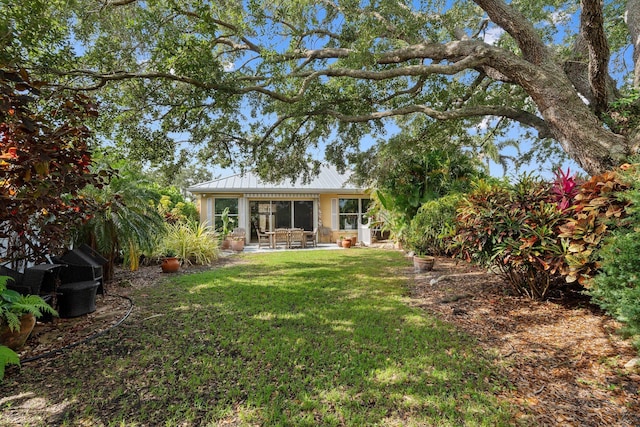 2683 SW Greenwich Way, Palm City, FL 34990 - back of property with a lawn, metal roof, a standing seam roof, and a patio area
