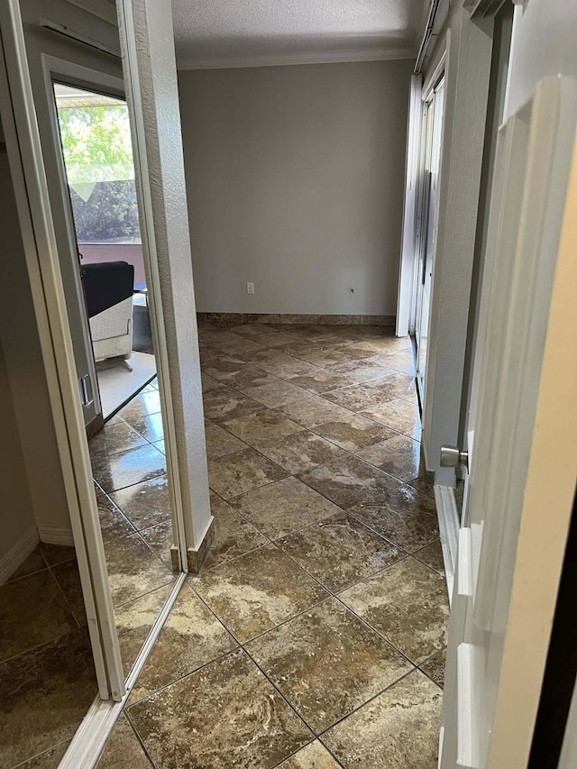 318 NW Byron St, Port Saint Lucie, FL 34983 - empty room featuring stone tile floors, a textured ceiling, ornamental molding, and baseboards
