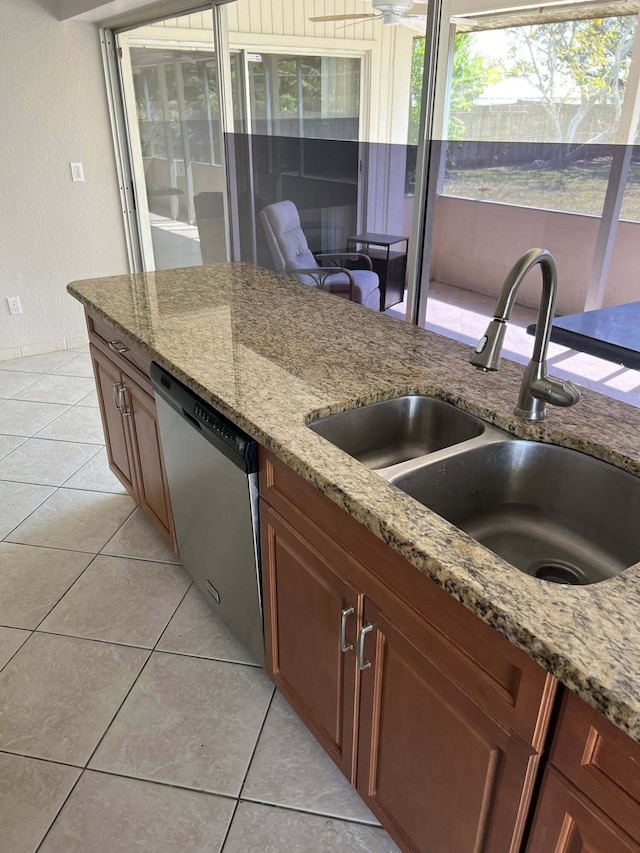 318 NW Byron St, Port Saint Lucie, FL 34983 - kitchen featuring stainless steel dishwasher, a sink, light stone countertops, light tile patterned floors, and a textured wall