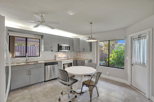 10112 Marwood Pl, Boynton Beach, FL 33437 - kitchen featuring appliances with stainless steel finishes, gray cabinets, a sink, decorative backsplash, and baseboards