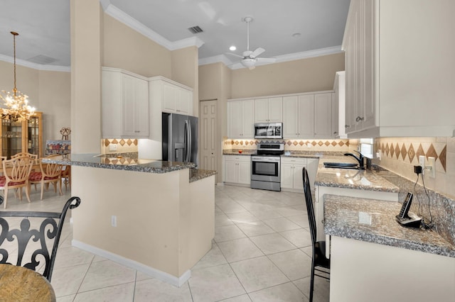 6908 Adriano Dr, Boynton Beach, FL 33437 - kitchen with stainless steel appliances, a peninsula, ornamental molding, backsplash, and ceiling fan