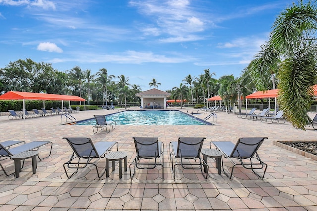 6908 Adriano Dr, Boynton Beach, FL 33437 - community pool featuring a patio and view of scattered trees