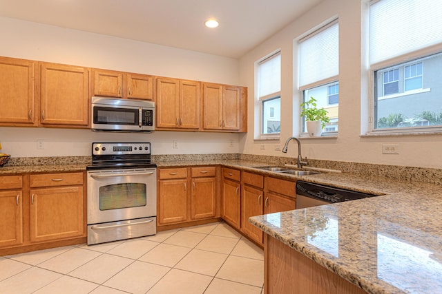 433 Amador Ln Unit 1, West Palm Beach, FL 33401 - kitchen featuring stainless steel appliances, a sink, light stone counters, light tile patterned flooring, and recessed lighting