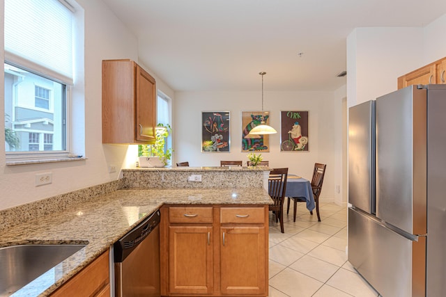 433 Amador Ln Unit 1, West Palm Beach, FL 33401 - kitchen with stainless steel appliances, a peninsula, pendant lighting, light tile patterned floors, and light stone countertops