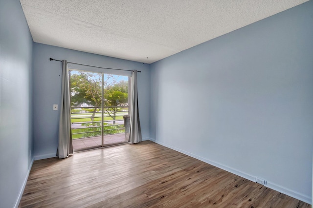 393 Fanshaw J, Boca Raton, FL 33434 - unfurnished room featuring wood finished floors, a textured ceiling, and baseboards