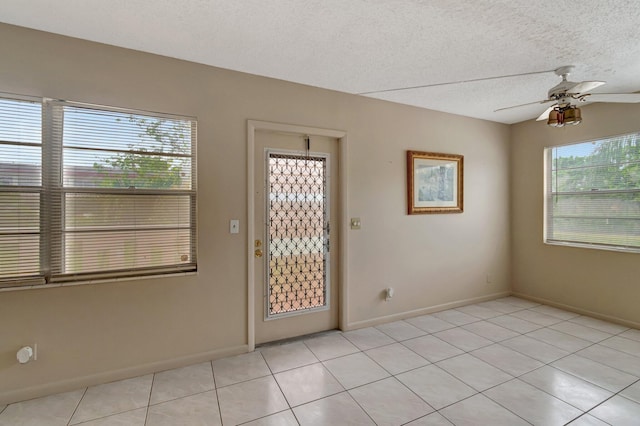 393 Fanshaw J, Boca Raton, FL 33434 - empty room featuring light tile patterned floors, a ceiling fan, a textured ceiling, and baseboards