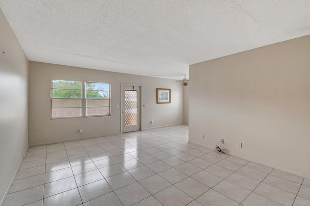 393 Fanshaw J, Boca Raton, FL 33434 - unfurnished room featuring a textured ceiling, ceiling fan, light tile patterned floors, and baseboards