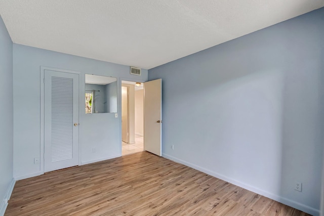 393 Fanshaw J, Boca Raton, FL 33434 - unfurnished bedroom featuring light wood-style flooring, baseboards, and a closet