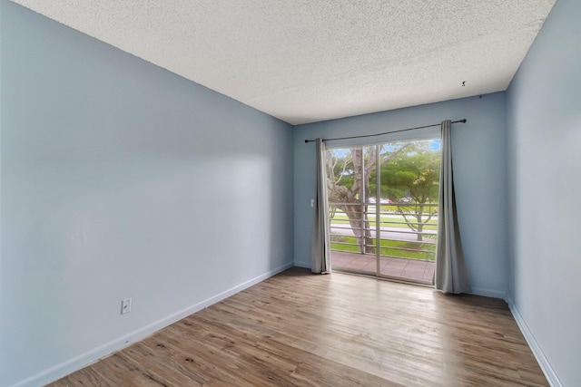 393 Fanshaw J, Boca Raton, FL 33434 - empty room with wood finished floors, a textured ceiling, and baseboards