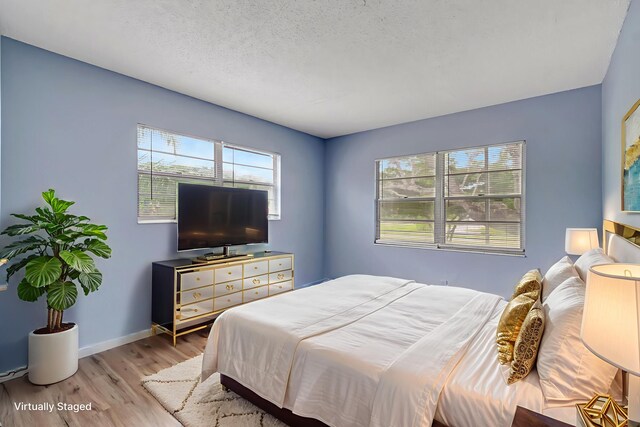 393 Fanshaw J, Boca Raton, FL 33434 - bedroom with wood finished floors, baseboards, and a textured ceiling