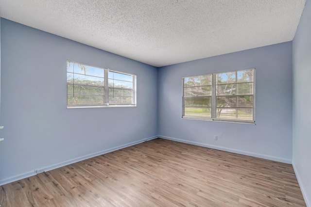 393 Fanshaw J, Boca Raton, FL 33434 - unfurnished room with light wood-style floors, a textured ceiling, and baseboards
