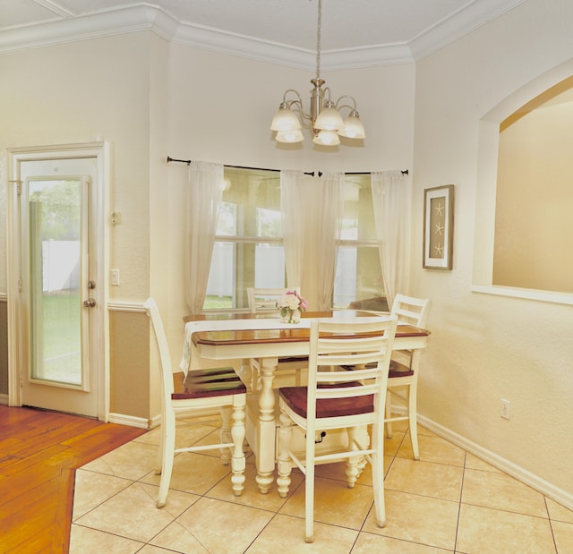 1985 SW Glenco St, Port Saint Lucie, FL 34953 - dining room featuring a chandelier, ornamental molding, arched walkways, baseboards, and wood finished floors