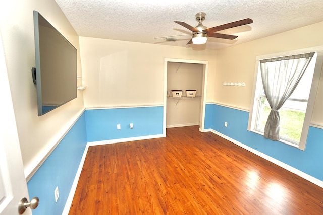 1985 SW Glenco St, Port Saint Lucie, FL 34953 - spare room with a textured ceiling, ceiling fan, wood finished floors, and baseboards
