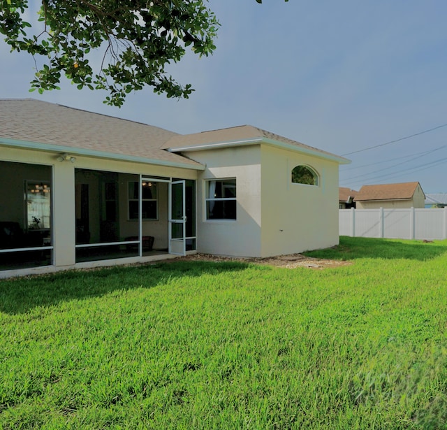 1985 SW Glenco St, Port Saint Lucie, FL 34953 - rear view of property featuring a sunroom, stucco siding, and roof with shingles