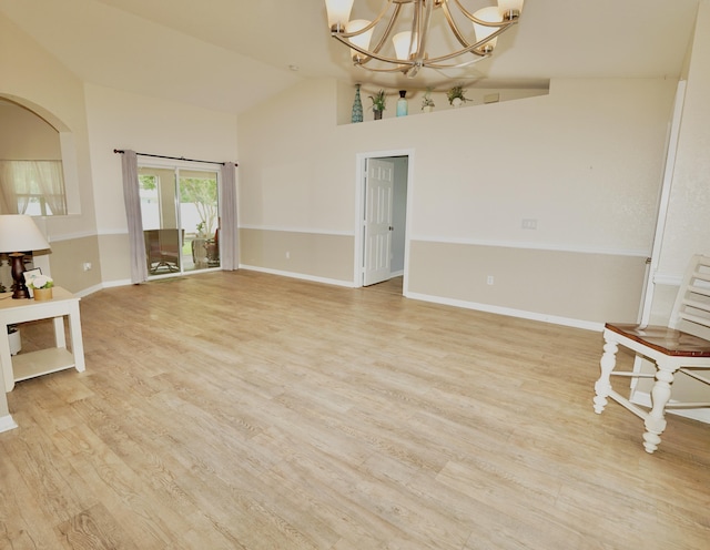 1985 SW Glenco St, Port Saint Lucie, FL 34953 - unfurnished living room with light wood-style floors, a chandelier, high vaulted ceiling, baseboards, and arched walkways