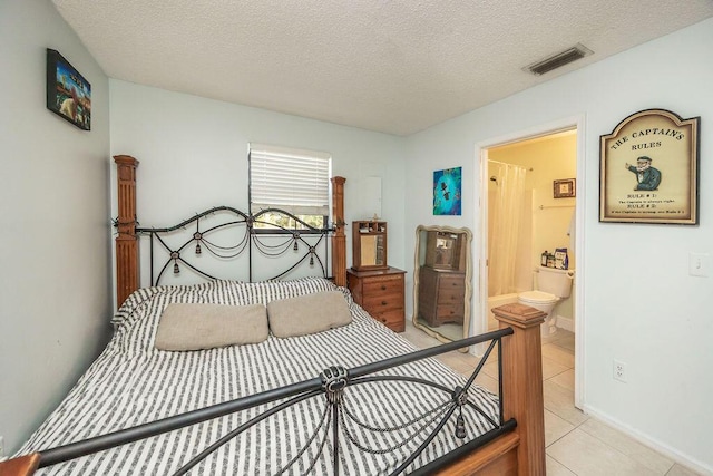 18564 48th Ave N, The Acreage, FL 33470 - bedroom with light tile patterned flooring, a textured ceiling, ensuite bath, and baseboards