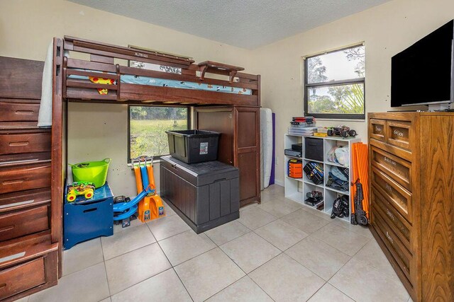 18564 48th Ave N, The Acreage, FL 33470 - bedroom with multiple windows, light tile patterned flooring, and a textured ceiling