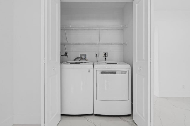 2949 NE 12th Ter, Pompano Beach, FL 33064 - laundry area with light marble finish floors and washing machine and clothes dryer