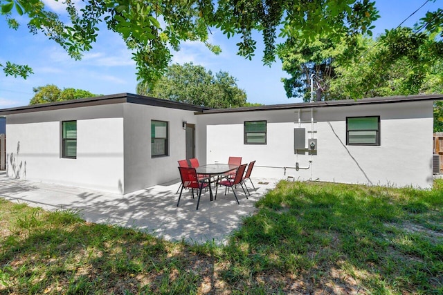 2949 NE 12th Ter, Pompano Beach, FL 33064 - rear view of property featuring a patio, stucco siding, and a yard