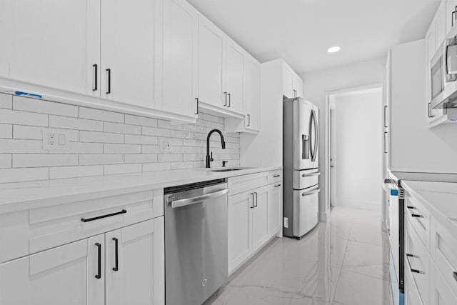 2949 NE 12th Ter, Pompano Beach, FL 33064 - kitchen with stainless steel appliances, a sink, white cabinetry, recessed lighting, and backsplash