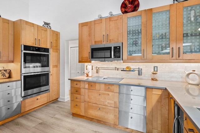 9391 Aqua Vista Blvd, Boynton Beach, FL 33437 - kitchen with appliances with stainless steel finishes, light wood-style flooring, light countertops, tasteful backsplash, and glass insert cabinets