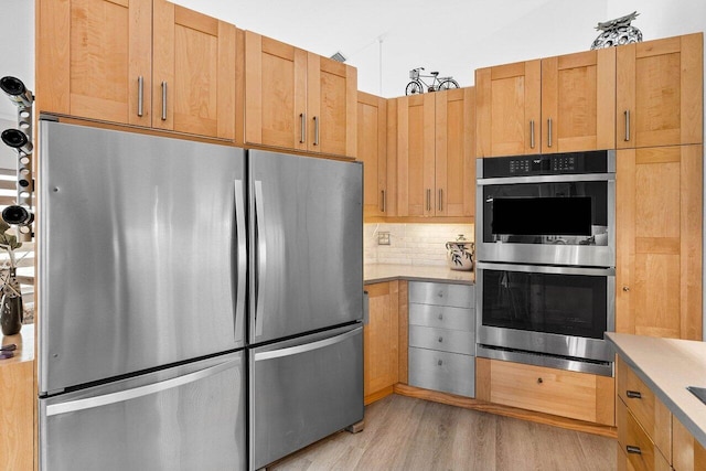 9391 Aqua Vista Blvd, Boynton Beach, FL 33437 - kitchen featuring stainless steel appliances, decorative backsplash, light wood-type flooring, and light countertops