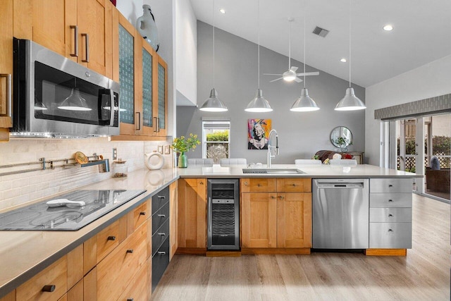 9391 Aqua Vista Blvd, Boynton Beach, FL 33437 - kitchen featuring appliances with stainless steel finishes, beverage cooler, a sink, high vaulted ceiling, and light wood-style flooring
