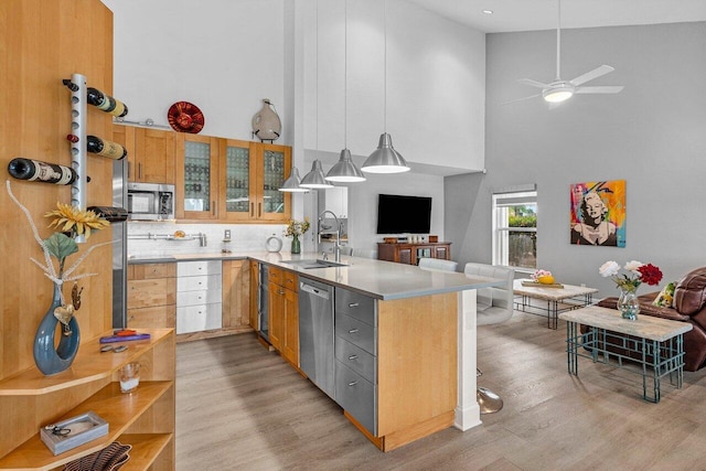 9391 Aqua Vista Blvd, Boynton Beach, FL 33437 - kitchen featuring a sink, stainless steel appliances, high vaulted ceiling, a peninsula, and light wood finished floors
