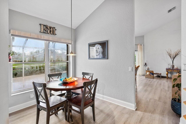 9391 Aqua Vista Blvd, Boynton Beach, FL 33437 - dining space with lofted ceiling, a textured wall, light wood-type flooring, plenty of natural light, and baseboards