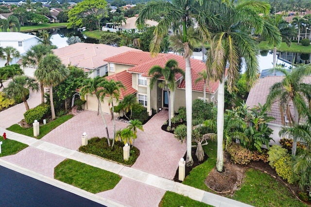 9391 Aqua Vista Blvd, Boynton Beach, FL 33437 - view of front of house featuring decorative driveway, a tile roof, a water view, stucco siding, and a residential view