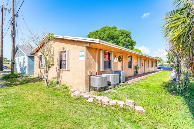 928 S H St Unit 1, Lake Worth, FL 33460 - view of side of property featuring stucco siding, a lawn, and cooling unit