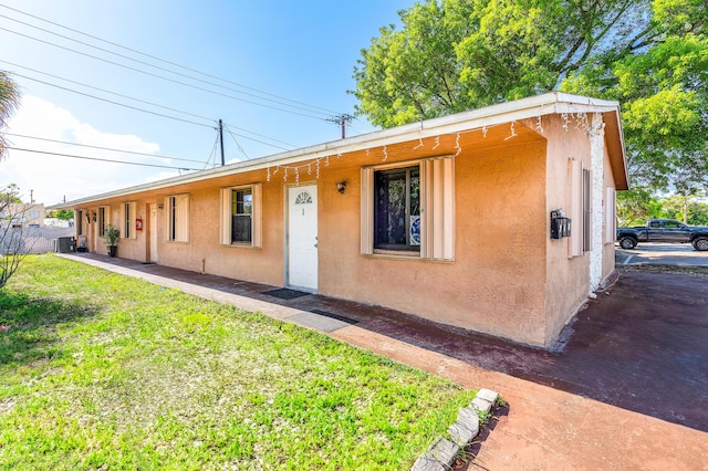 928 S H St Unit 1, Lake Worth, FL 33460 - view of front of home with stucco siding, cooling unit, and a front yard