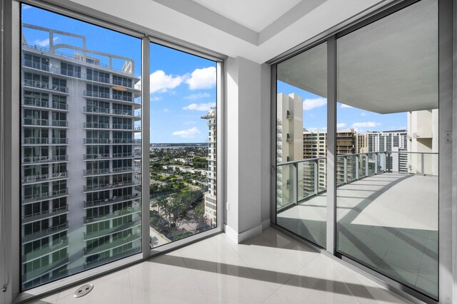 3100 N Ocean Dr Unit H-1608, Singer Island, FL 33404 - unfurnished room featuring a city view, tile patterned floors, baseboards, and floor to ceiling windows