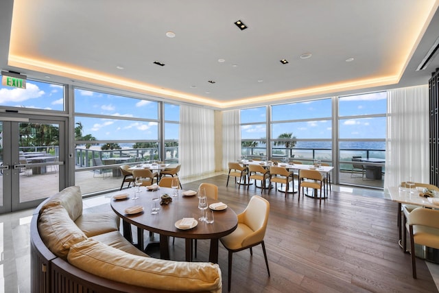3100 N Ocean Dr Unit H-1608, Singer Island, FL 33404 - dining area with floor to ceiling windows, a raised ceiling, wood finished floors, a water view, and french doors
