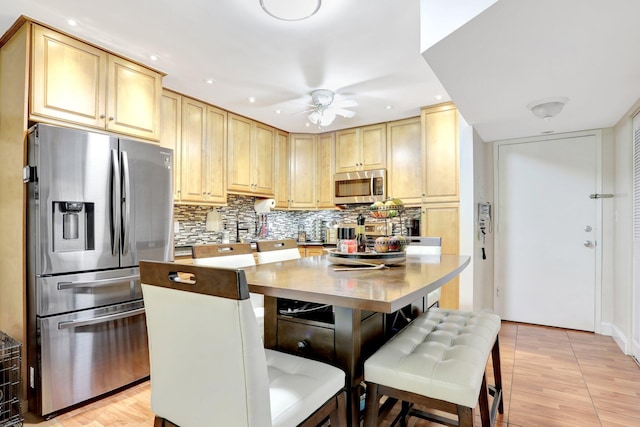 257 S Cypress Rd Unit 449, Pompano Beach, FL 33060 - kitchen featuring stainless steel appliances, light brown cabinets, a ceiling fan, decorative backsplash, and recessed lighting