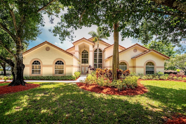 1414 SW Osprey Cv, Port Saint Lucie, FL 34986 - mediterranean / spanish-style house with stucco siding, a front yard, and a tiled roof