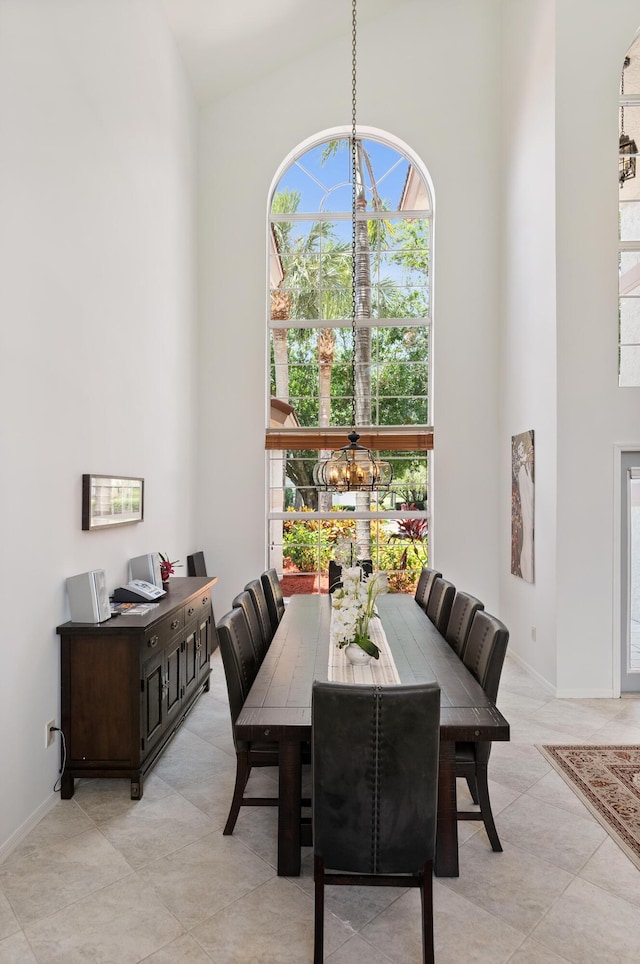 1414 SW Osprey Cv, Port Saint Lucie, FL 34986 - dining space featuring a towering ceiling, a chandelier, light tile patterned floors, and baseboards